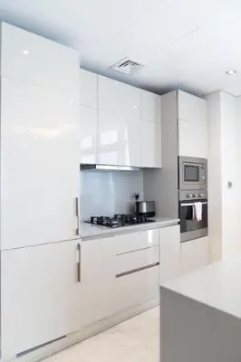 a white kitchen with white cabinets and appliances at Elegant Palm Jumeirah Retreat with Breathtaking Sea Views By AYA Boutique in Dubai