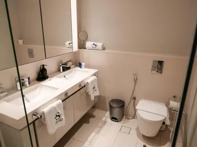 a bathroom with a sink and a toilet and a mirror at Glamorous 3BR with Marina view in Dubai