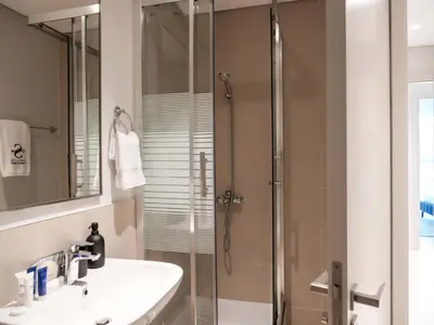 a bathroom with a sink and a glass shower at Glamorous 3BR with Marina view in Dubai