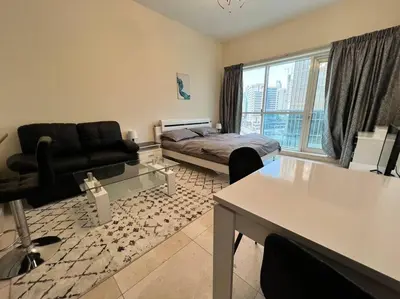 a living room with a bed and a couch at Studio - Steps from Downtown in Dubai