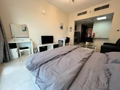 a bedroom with a bed and a living room at Studio - Steps from Downtown in Dubai