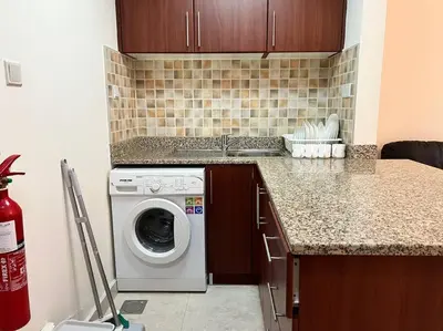 a kitchen with a washing machine and a counter at Studio - Steps from Downtown in Dubai