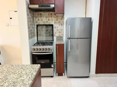 a kitchen with a stainless steel refrigerator and a stove at Studio - Steps from Downtown in Dubai