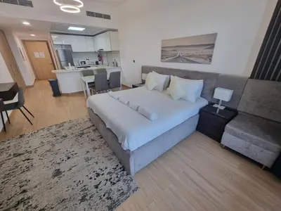 a bedroom with a large bed and a couch at 151 Residence Jumeirah Gardens in Dubai