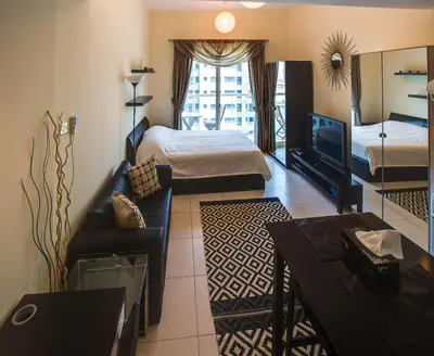 a hotel room with two beds and a television at Beautiful Studio on 10 floor of Marina View Tower in Dubai