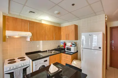 a kitchen with a white refrigerator and a sink at Beautiful Studio on 10 floor of Marina View Tower in Dubai