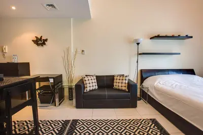 a bedroom with a bed and a chair and a desk at Beautiful Studio on 10 floor of Marina View Tower in Dubai