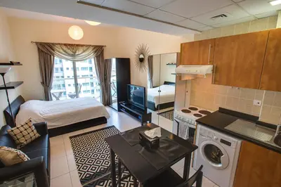 a room with a kitchen and a bedroom with a bed at Beautiful Studio on 10 floor of Marina View Tower in Dubai