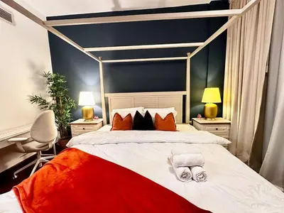 a bedroom with a red and white bed with two lamps at Cozy Apartment In Laya Residence JVC in Dubai