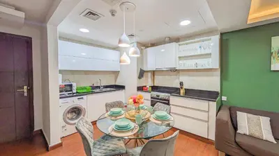 a kitchen and dining room with a table and chairs at Cozy Apartment In Laya Residence JVC in Dubai