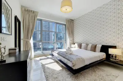 a bedroom with a large bed with a teddy bear on it at Standpoint A, Downtown - Contemporary One Bedroom in Dubai
