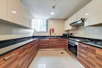 a large kitchen with wooden cabinets and a stove at Vacationer I Sparkle T1 2 Bedroom I Marina Views I Steps away from Beach I Gym, Pool, Parking & Wi-Fi in Dubai