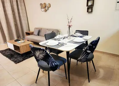 a dining table and chairs in a living room at RH- Unwind and Relax, 1BR, Burj View from balcony, Downtown in Dubai