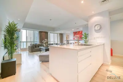 an open kitchen and living room with a large island at Alluring 2BR at Al Majara 1 Dubai Marina by Deluxe Holiday Homes in Dubai