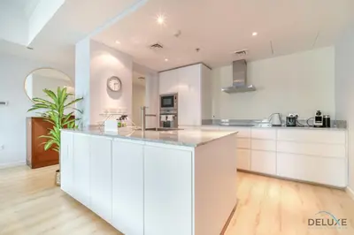 a kitchen with white cabinets and a counter top at Alluring 2BR at Al Majara 1 Dubai Marina by Deluxe Holiday Homes in Dubai