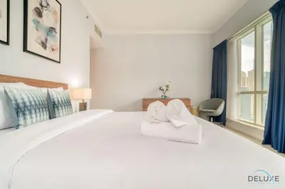a bedroom with a large white bed with towels on it at Alluring 2BR at Al Majara 1 Dubai Marina by Deluxe Holiday Homes in Dubai
