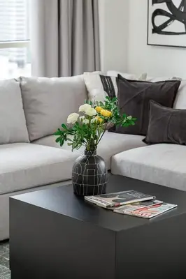 a vase with flowers on a coffee table in a living room at Frank Porter - West Avenue in Dubai