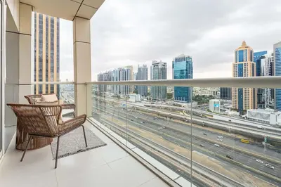 a chair on a balcony with a view of the city at Frank Porter - West Avenue in Dubai