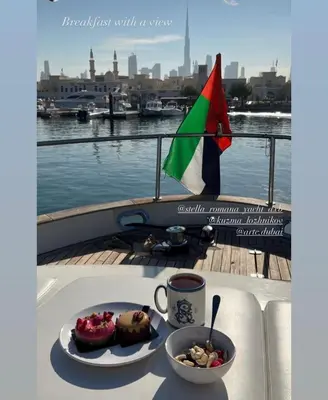 a table with a plate of food and a cup of coffee at Yacht Experience - Stella Romana in Dubai
