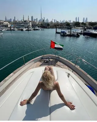 a woman is sitting on a boat in the water at Yacht Experience - Stella Romana in Dubai