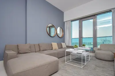 a living room with a couch and a table at Spacious 1BR with Balcony & Rooftop Pool The Bay Business Bay in Dubai