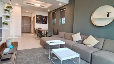 a living room with a couch and a table at Spacious 1BR with Balcony & Rooftop Pool The Bay Business Bay in Dubai