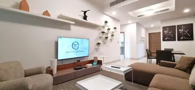 a living room with a couch and a flat screen tv at Spacious 1BR with Balcony & Rooftop Pool The Bay Business Bay in Dubai