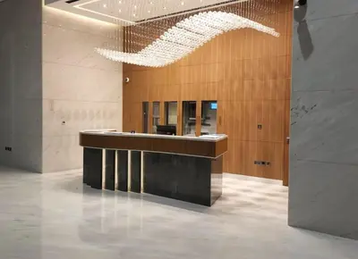 an office lobby with a reception desk and a chandelier at Spacious 1BR with Balcony & Rooftop Pool The Bay Business Bay in Dubai
