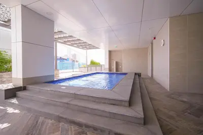 a swimming pool in the middle of a building at Spacious 1BR with Balcony & Rooftop Pool The Bay Business Bay in Dubai