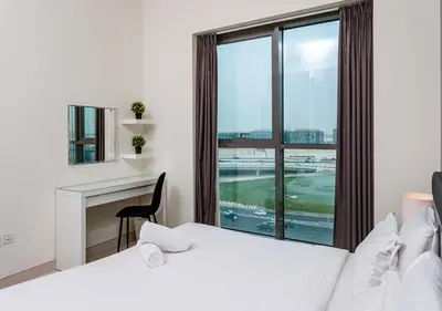 a bedroom with two beds and a desk and a window at Spacious 1BR with Balcony & Rooftop Pool The Bay Business Bay in Dubai