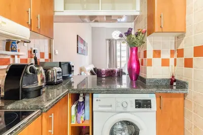 a kitchen with a vase of flowers on the counter at Holiday Home near beach & metro in Dubai