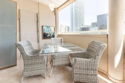a table and chairs on a balcony with a window at Holiday Home near beach & metro in Dubai