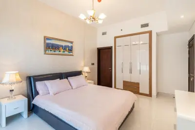 a bedroom with a bed and a night stand with a lamp at Superb Amenities - 1BR in Resortz by Danube,Arjan - Allsopp&Allsopp in Dubai