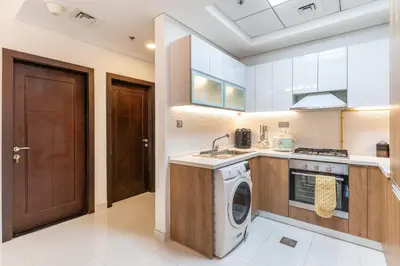 a kitchen with a washer and dryer in it at Superb Amenities - 1BR in Resortz by Danube,Arjan - Allsopp&Allsopp in Dubai