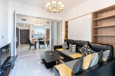 a living room with a black leather couch and a table at Superb Amenities - 1BR in Resortz by Danube,Arjan - Allsopp&Allsopp in Dubai