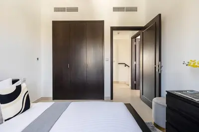 a bedroom with a bed and a wooden door at Frank Porter - Serena Casa Viva in Dubai
