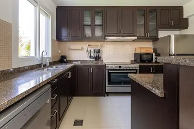 a kitchen with brown cabinets and a large window at Frank Porter - Serena Casa Viva in Dubai
