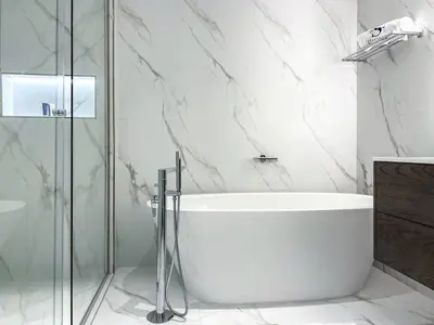 a white bathroom with a tub and a glass shower at Fantastic flat in TiaraResidence in Dubai