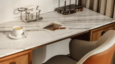 a desk with a cup of coffee and a pen at Jumeirah Residences Marsa Al Arab Dubai in Dubai