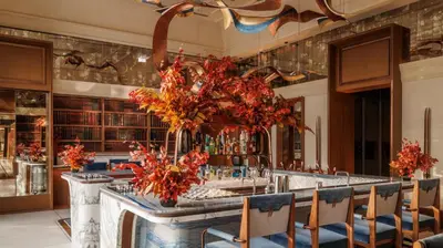 a bar in a restaurant with red flowers at Jumeirah Marsa Al Arab Dubai in Dubai