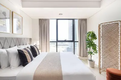 a bedroom with a large white bed with a large window at Frank Porter - Goldcrest Views 2 in Dubai