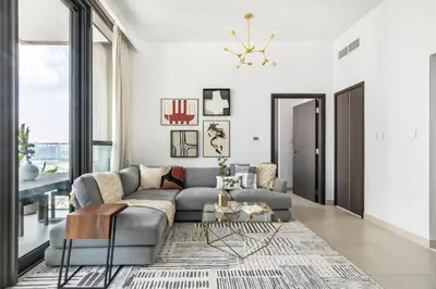 a living room with a gray couch and a large window at GuestReady - Modern home with stunning city views in Dubai