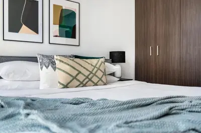 a bedroom with a bed with a wooden cabinet at GuestReady - Modern home with stunning city views in Dubai
