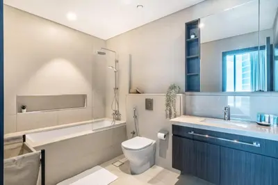 a bathroom with a toilet and a tub and a sink at GuestReady - Modern home with stunning city views in Dubai