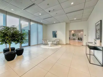 an empty lobby with plants and a piano at GuestReady - Modern home with stunning city views in Dubai