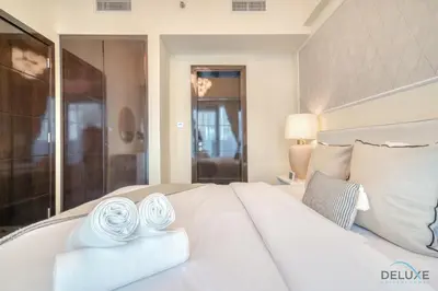 a bedroom with a white bed with towels on it at Graceful 1BR at Merano Business Bay by Deluxe Holiday Homes in Dubai
