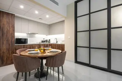 a kitchen with a wooden table and chairs at Happy ACADEMIA JBR in Dubai