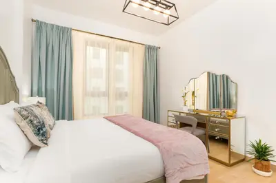 a bedroom with a bed and a desk and a mirror at Stylish 1BR Apartment in La Mer Dubai with Balcony and Partial Marina Views in Dubai