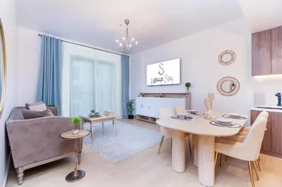 a living room with a couch and a table at Stylish 1BR Apartment in La Mer Dubai with Balcony and Partial Marina Views in Dubai