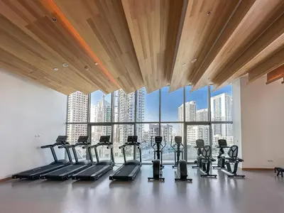 a gym with a view of a city skyline at Urban tropic 3 bedroom apartment with full sea view by Suiteable Interiors in Dubai